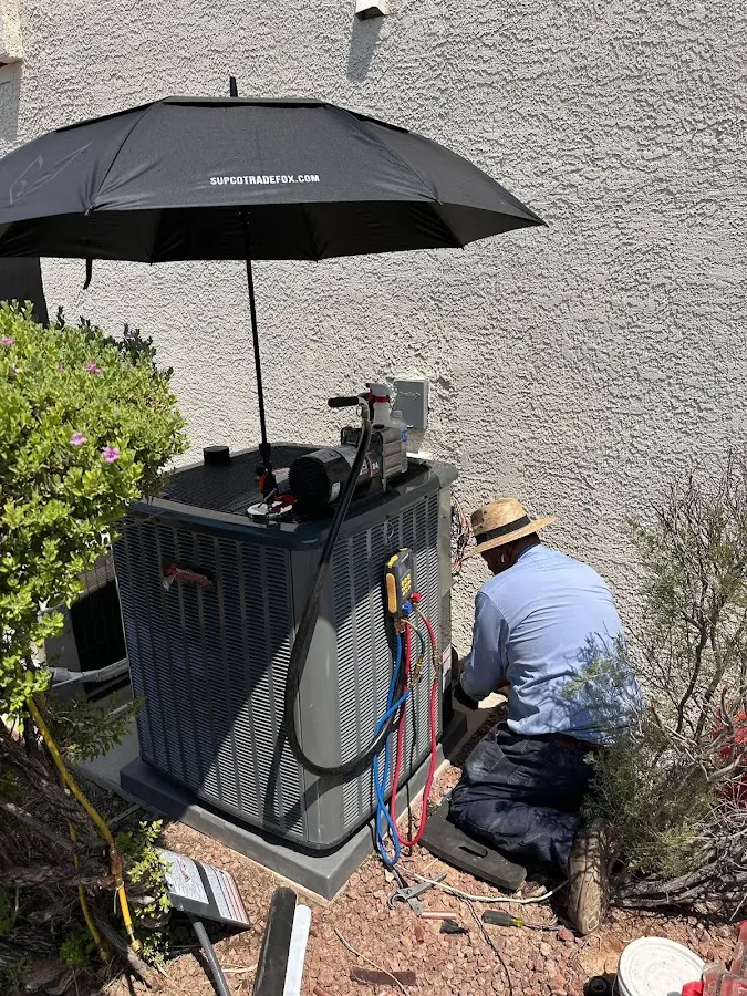 HVAC technician performing outdoor AC maintenance in Ligonier