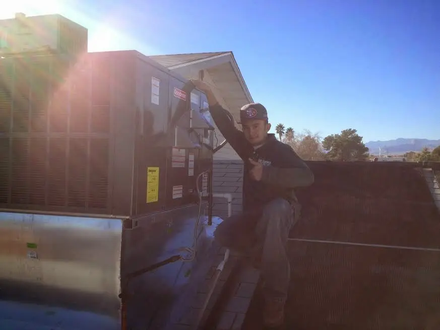 HVAC technician performing HVAC Inspection on a rooftop unit in Ligonier